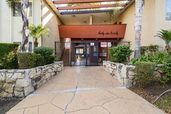 the entrance to a building with a stone walkway and a gate
